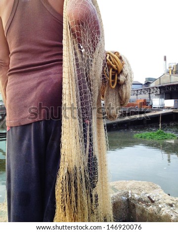 Fisherman pulling in his Fishing Net. Photo captured with an iPhone. 