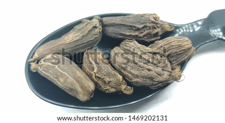 A picture of black Cardamom on black spoon