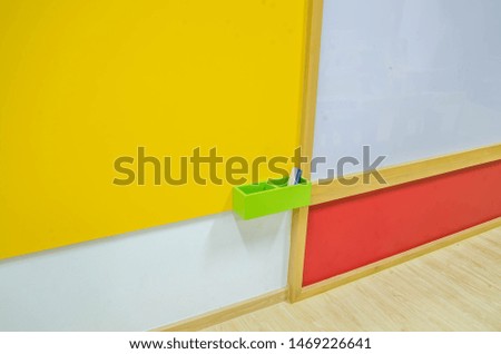 Colorful background of wall in the classroom which have whiteboard and knowledge board.