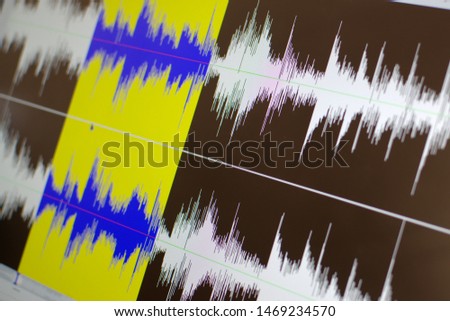Close up shot of a computer screen showing a waveform sound visualization in an audio editing software.