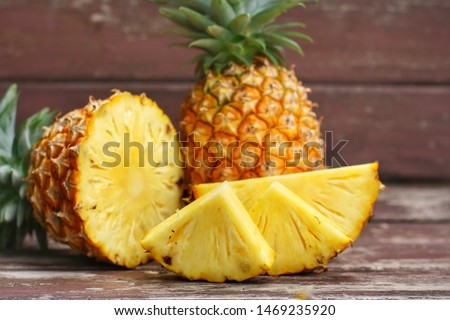 Close up at Sliced and whole of Pineapple(Ananas comosus) on wooden table background.Sweet,sour and juicy taste.Have a lot of fiber,vitamins C and minerals.Food,Fruits or healthcare concept. Royalty-Free Stock Photo #1469235920