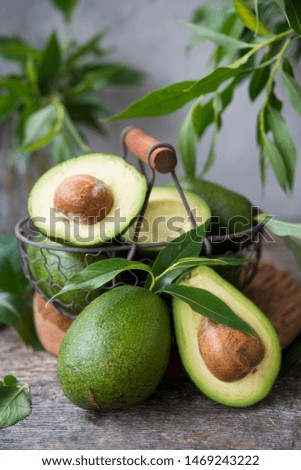 Fresh green avocado on wooden background. Selective focus. Vertical orientation.