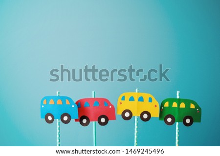 toy cars cut out of colored cardboard on a blue background