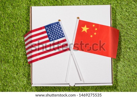 Paper box of pizza with flags of America and China on the grass. Concept of peace, partnership and friendship, . Top view
