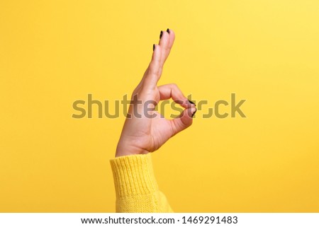 hand ok sign over trend yellow background Royalty-Free Stock Photo #1469291483