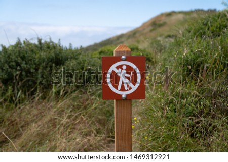 No hiking cross out warning sign in a dangerous area on a trail