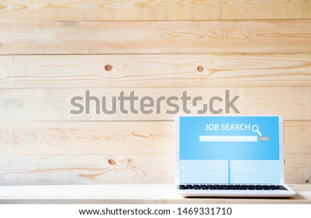 Online job search engine on laptop  on wood table
