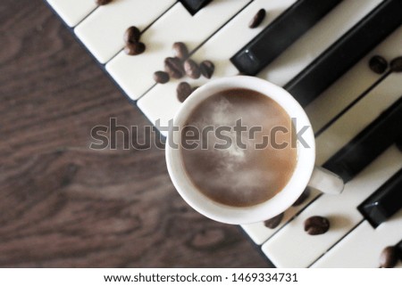 Cup of hot coffee on the piano, top view