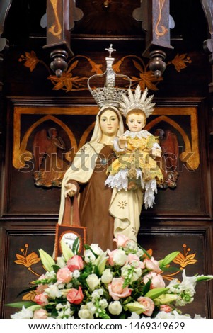Statue of the image of Our Lady of Carmel, Nossa Senhora do Carmo, mother of God in the Catholic religion, decorated with flowers