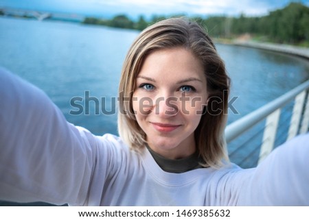 Young woman taking a selfie close up on water background