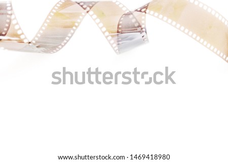 Blurry picture of a twirling roll of negative film on white background with white copy space for text