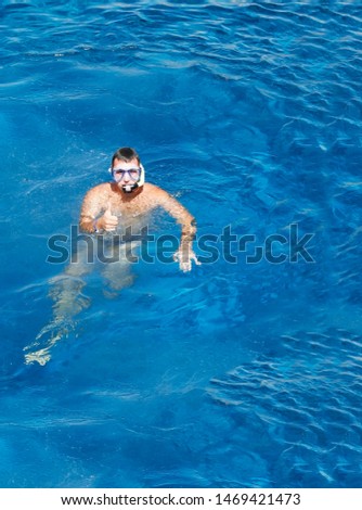 young man in a mask floats in the sea.