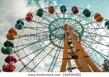 Bright ferris wheel in the summer against the blue sky