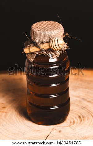 Honey container on a rustic wooden table.