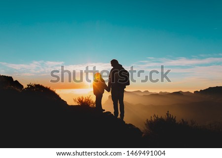 father and daughter travel in mountains at sunset