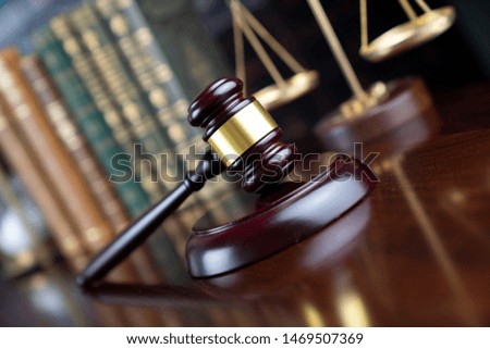Judge's gavel, scales of justice, hourglass, books. Bokeh background.