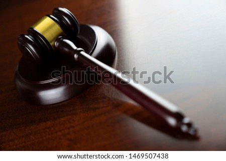 Judge's gavel, scales of justice, hourglass, books. Bokeh background.