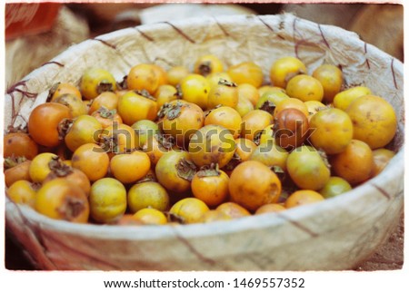 Ripe orange persimmon fruit in a wicker basket
