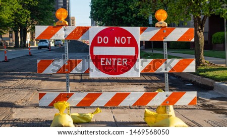 Do not enter, road works. Road sign, text do not enter and barricade, urban background. Sunny spring day