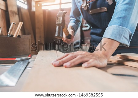 Carpenter working with equipment on wooden table in carpentry shop. woman works in a carpentry shop. Royalty-Free Stock Photo #1469582555