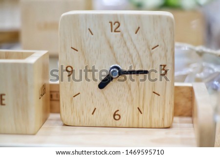 Wooden home clock. Top view of wooden clock with hands on blur background.