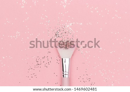 Makeup brush and shiny sparkles on pastel pink background. Festive magic makeup concept. Template for design, Top view Flat Lay Copy space. Royalty-Free Stock Photo #1469602481