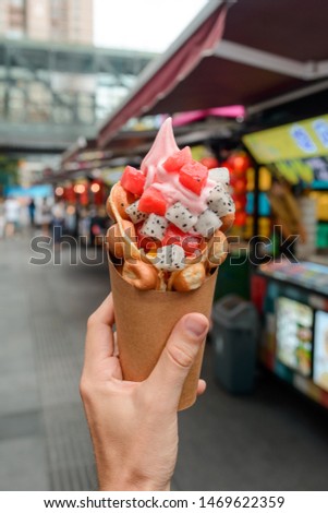 Fruit ice cream in a bubble waffle cone. Chinese street food and desserts.
