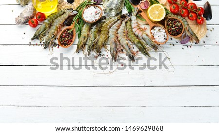 black tiger prawns with lemon. Seafood. Top view. On a white wooden background. Free copy space.