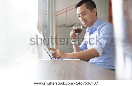 Asian businessman using his smart phone, computer in his office