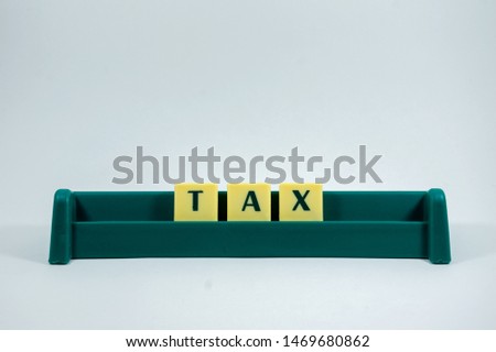 Tax word concept light background image using by block letter for various purposes of tax return or tax related work 