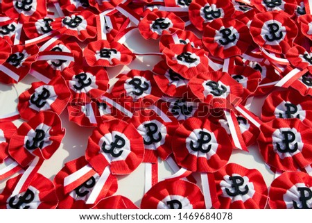 Many badges in the  with an colors of the Polish flag: white-red with an anchor in the shape of the letter P - a symbol of the Warsaw Uprising Royalty-Free Stock Photo #1469684078