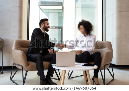 Smiling diverse business partners shaking hands at meeting, greeting, African American businesswoman and Caucasian businessman handshaking, making agreement, successful job interview or negotiations Royalty-Free Stock Photo #1469687864