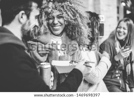 Happy friends from diverse culture eating street food outdoor - Yong trendy people having fun together drinking and laughing - City lifestyle and party concept - Focus on black girl face