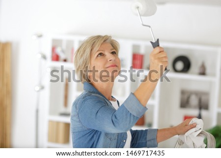 a senior woman is painting