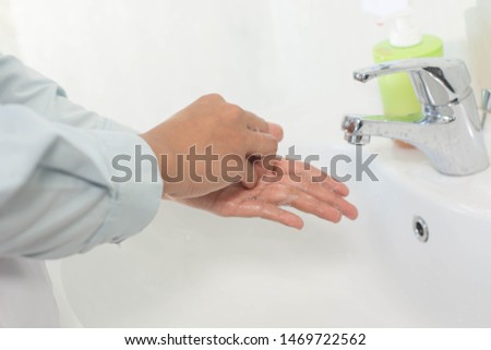 Close up image of hand and sleeves washing in the sink with medical procedure step - Image