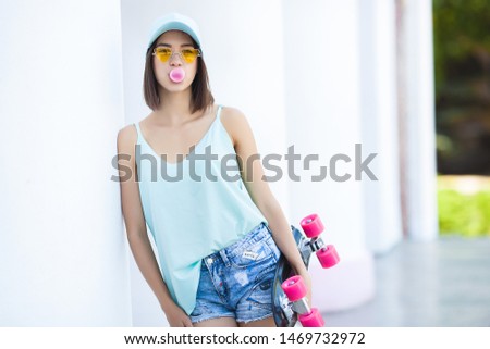 Young woman with skate. Female skater. Beautiful woman outdoors.