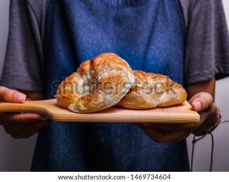 presenting warm fresh croissants on wood cutting board