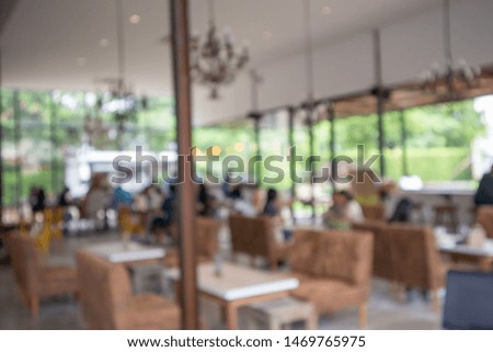 Blurred people are drinking coffee and giving food in the coffee shop