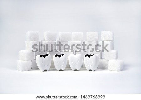 Heap of a lot of cubes sugar Surround Decayed Teeth, Control the amount of sugar you consume protect your oral health                                                   