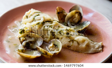 Fish dish from a restaurant. 
Hake with clam