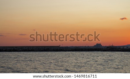 Beautiful golden sunset on the Black Sea, dark silhouettes of the shore. The beautiful nature around.