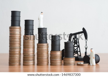 Arab man, Oil pump jack and barrels on step stack coins as graph down. Bear market in crude oil commodity market investment and petroleum industry. Oil prices fall due to over supply production 