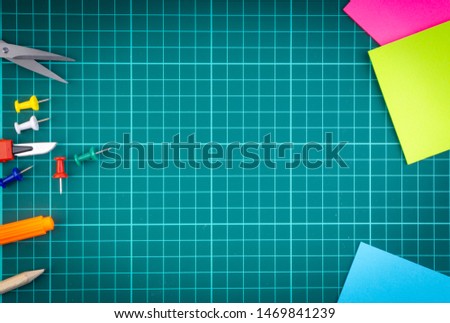 Knives cutter, pencil, scissor and stationary on white green cutting mat background. Selective focus and copy space