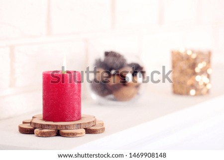 Christmas candle on white fireplace