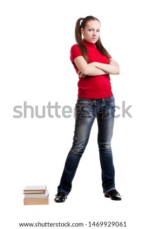 Beautiful girl on a white background stands next to a stack of books, in isolation