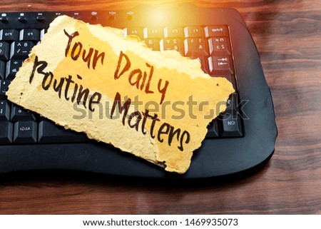 your daily routine matters concept on old carton tear card above black keyboard