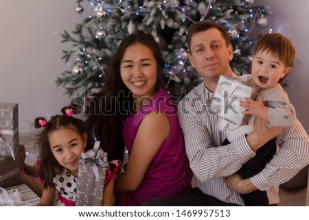 A young family with young children at Christmas. New Year photo session in the studio. Happy large family in anticipation of Christmas