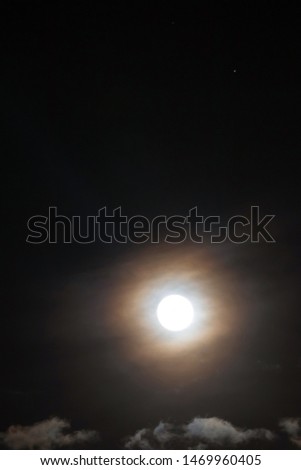 Full moon shining glowing light the night sky with star; long exposure for beautiful nature background.