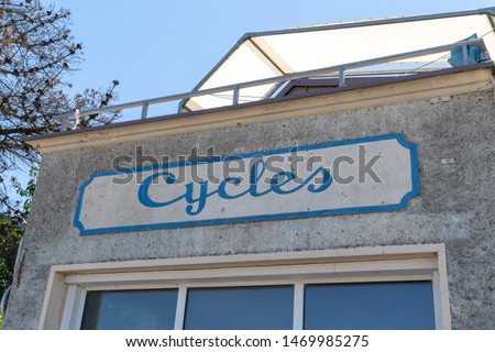Cylcles in french means Bike shop in vintage rusty sign in ancient building