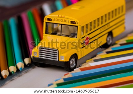 Back to school color pencils on light yellow school bus